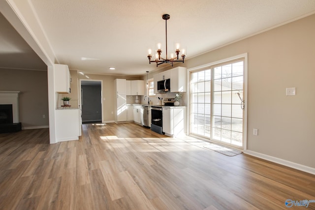 kitchen with white cabinetry, crown molding, decorative light fixtures, stainless steel appliances, and light hardwood / wood-style floors