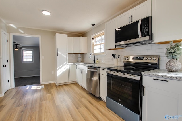 kitchen featuring white cabinetry, sink, light stone counters, and stainless steel appliances