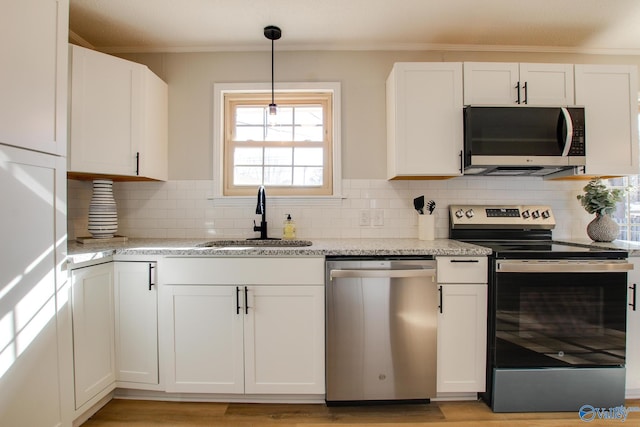 kitchen with appliances with stainless steel finishes, sink, and white cabinets