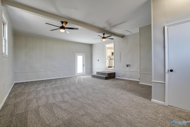 unfurnished living room featuring ceiling fan, beamed ceiling, and carpet