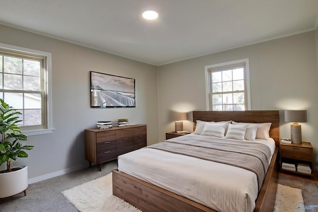 bedroom featuring multiple windows, ornamental molding, and carpet