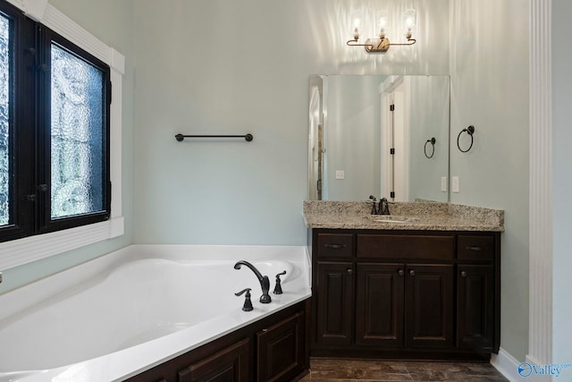 11 SE Braewick Pl, Gurley, AL 35748 - full bathroom featuring vanity, a garden tub, plenty of natural light, and wood finished floors