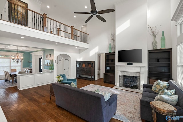 11 SE Braewick Pl, Gurley, AL 35748 - living area featuring a ceiling fan, a high ceiling, arched walkways, dark wood-type flooring, and a premium fireplace