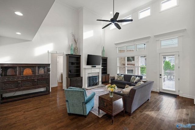 11 SE Braewick Pl, Gurley, AL 35748 - living area featuring a high ceiling, dark wood-type flooring, a ceiling fan, a fireplace with flush hearth, and baseboards