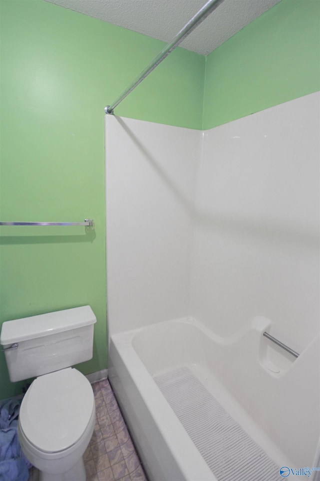 full bath featuring a textured ceiling and toilet