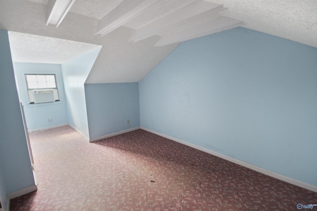 bonus room featuring a textured ceiling, vaulted ceiling, and baseboards