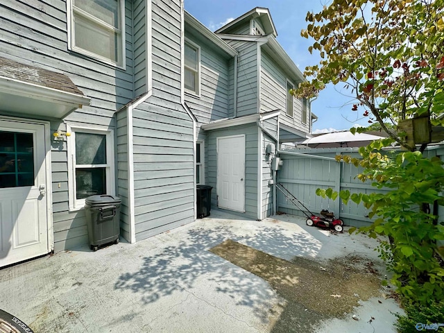 view of home's exterior with fence and a patio