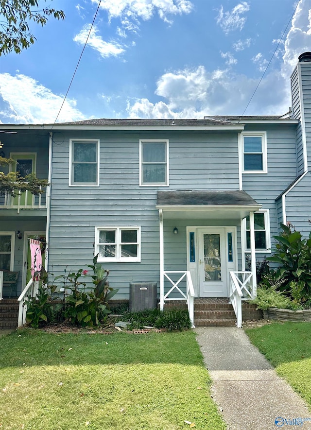 view of front of home featuring covered porch, central AC unit, and a front lawn