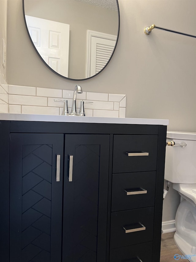 bathroom featuring vanity, toilet, wood-type flooring, and a textured ceiling