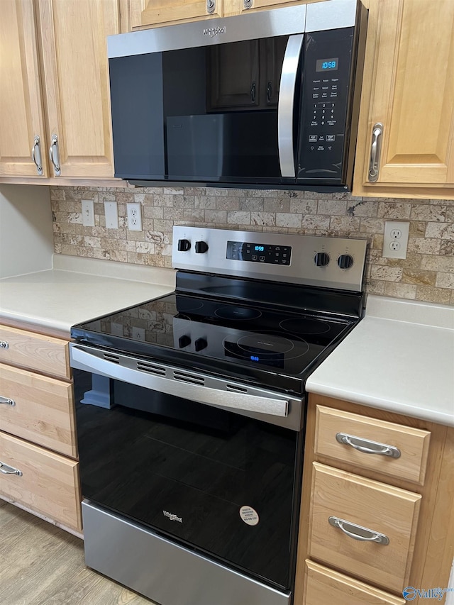 kitchen featuring light brown cabinetry, decorative backsplash, light hardwood / wood-style flooring, and stainless steel range with electric cooktop