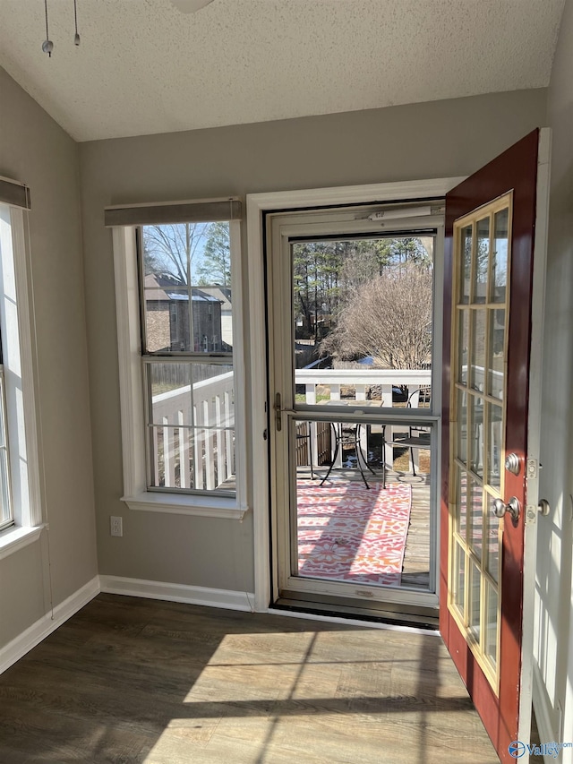 doorway to outside with dark hardwood / wood-style floors and a textured ceiling