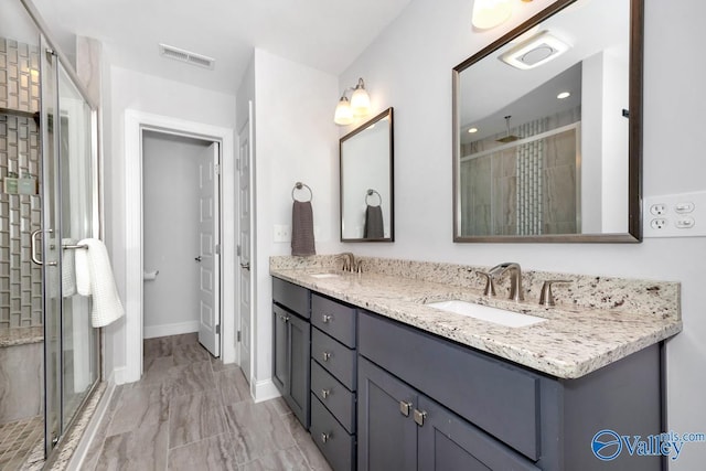 bathroom with a stall shower, visible vents, and a sink