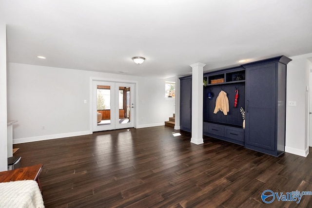 unfurnished living room featuring baseboards, french doors, stairway, dark wood-style floors, and decorative columns