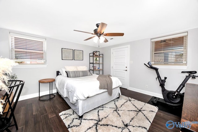 bedroom with multiple windows, baseboards, and wood finished floors