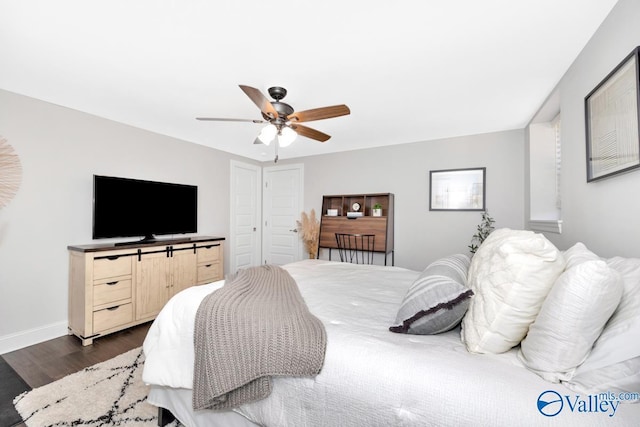 bedroom featuring dark wood-type flooring, a closet, a ceiling fan, and baseboards