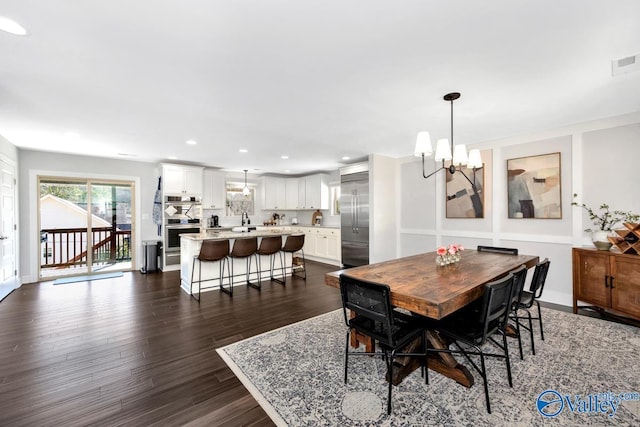 dining space featuring recessed lighting, dark wood-type flooring, visible vents, baseboards, and an inviting chandelier