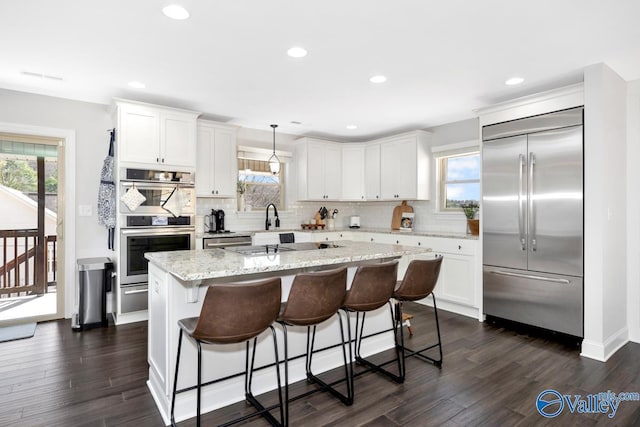 kitchen with a healthy amount of sunlight, appliances with stainless steel finishes, and white cabinets