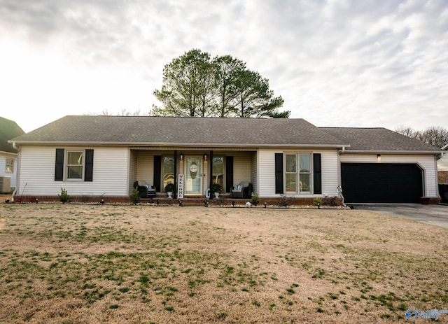 ranch-style house featuring a front yard, driveway, a garage, and covered porch