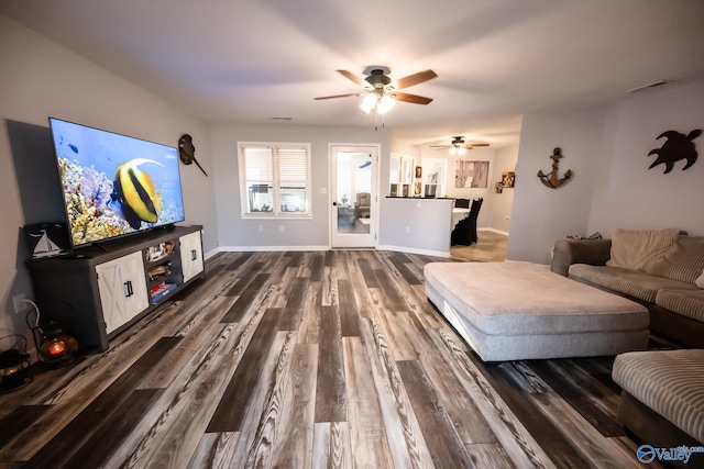 living room featuring dark wood-style floors, baseboards, and ceiling fan