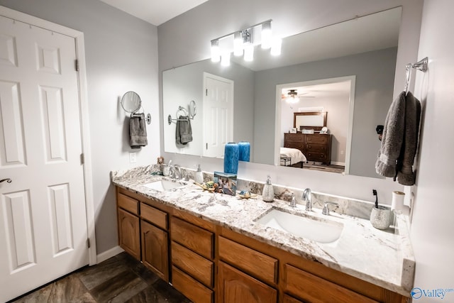 full bathroom with double vanity, a sink, a ceiling fan, and ensuite bath