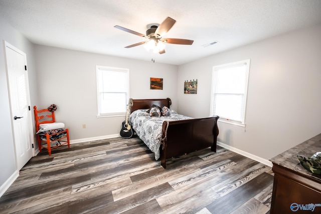 bedroom featuring wood finished floors, visible vents, ceiling fan, and baseboards
