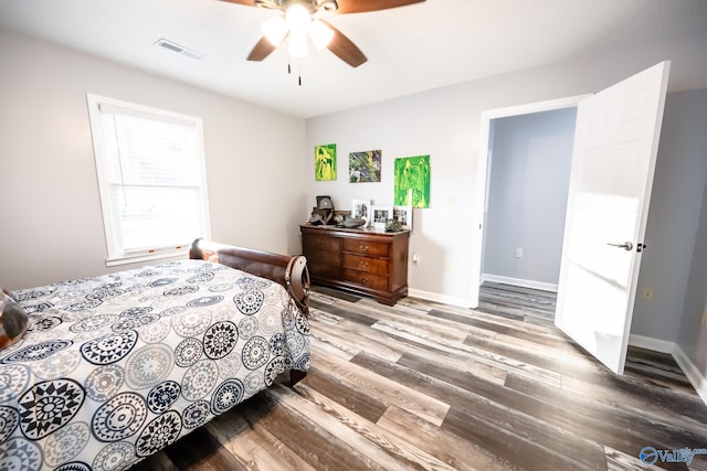 bedroom with baseboards, visible vents, wood finished floors, and a ceiling fan