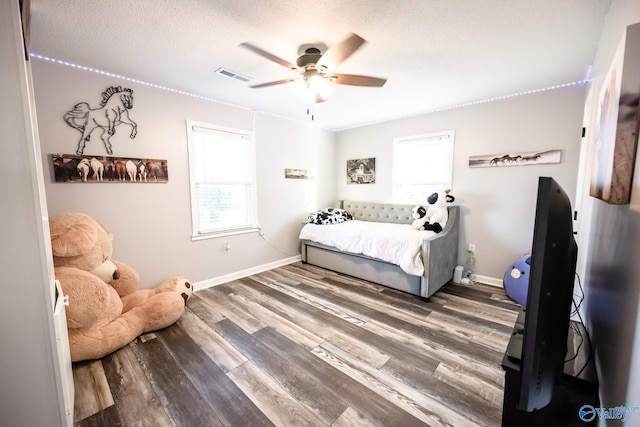 bedroom featuring baseboards, visible vents, wood finished floors, and a ceiling fan