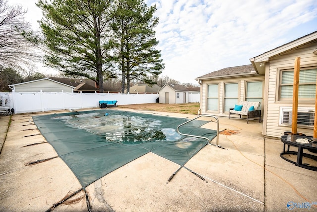 view of swimming pool with a patio area, a diving board, an outdoor structure, a fenced in pool, and a fenced backyard