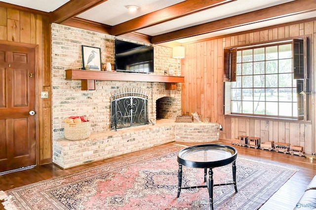 living room with wood finished floors, beam ceiling, and wood walls