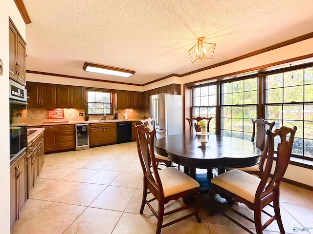 dining space with a notable chandelier, crown molding, and beverage cooler