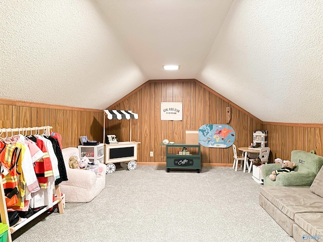 living area with lofted ceiling, a textured ceiling, wooden walls, and carpet floors