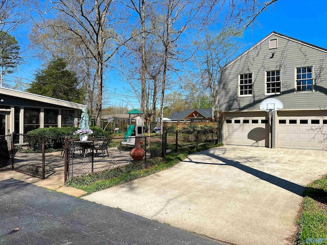 view of side of home with a garage, fence, concrete driveway, and a playground