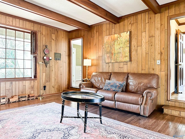 living room featuring beamed ceiling, wood walls, and hardwood / wood-style flooring
