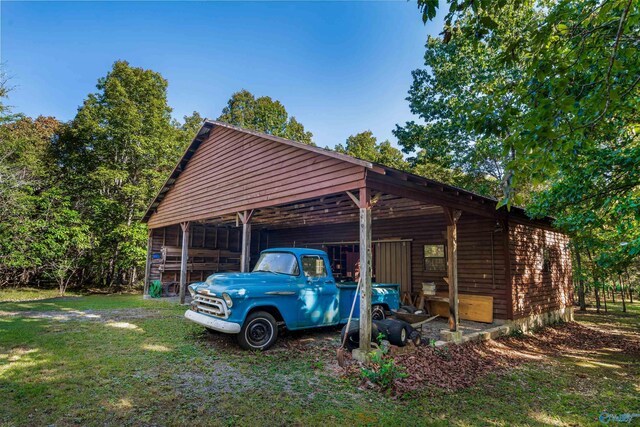 exterior space featuring a lawn, an outdoor structure, and a carport