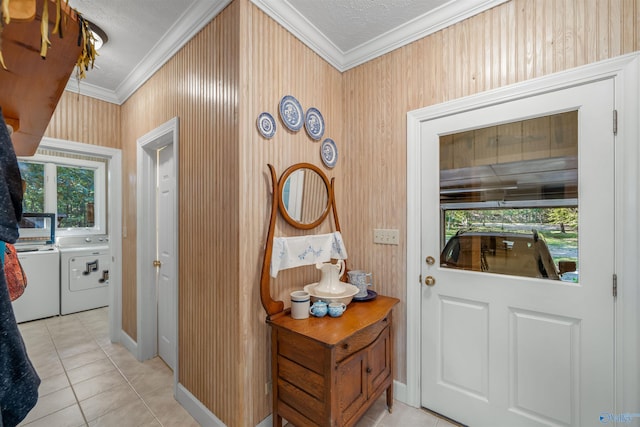 foyer featuring ornamental molding, a textured ceiling, independent washer and dryer, and light tile patterned flooring