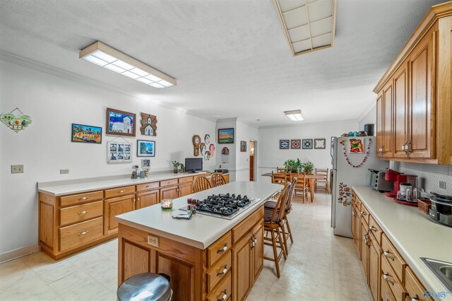 251 Wells St, Mentone, AL 35984 - kitchen with stainless steel gas stovetop, a kitchen breakfast bar, light countertops, and ornamental molding