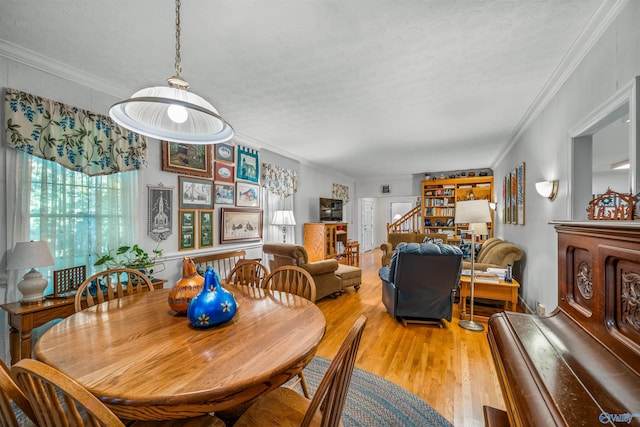 dining area featuring wood-type flooring, crown molding, and a textured ceiling