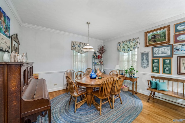 dining area featuring light wood-type flooring and ornamental molding