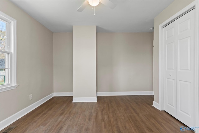 unfurnished bedroom featuring a closet, wood finished floors, baseboards, and visible vents