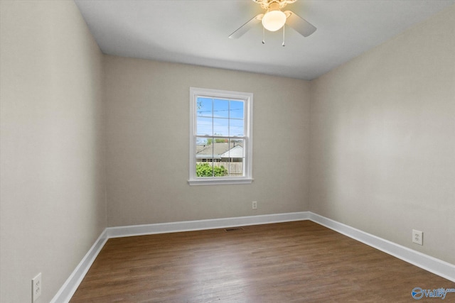 unfurnished room featuring visible vents, baseboards, a ceiling fan, and dark wood finished floors