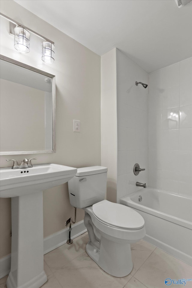 bathroom featuring baseboards, a sink, toilet, shower / bathing tub combination, and tile patterned floors