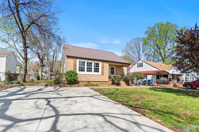 view of front facade featuring crawl space, metal roof, a front yard, fence, and concrete driveway