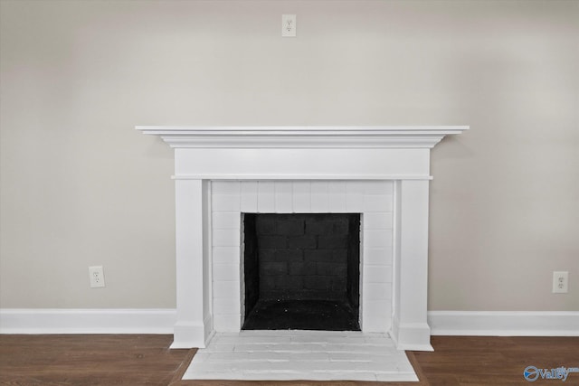 interior details with wood finished floors, a fireplace, and baseboards