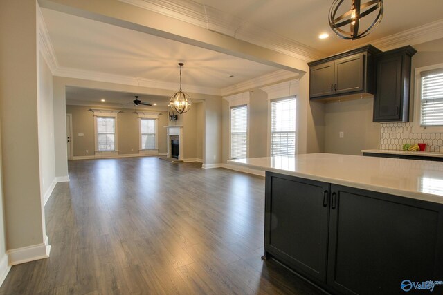 kitchen featuring dark wood-style floors, pendant lighting, decorative backsplash, and light countertops