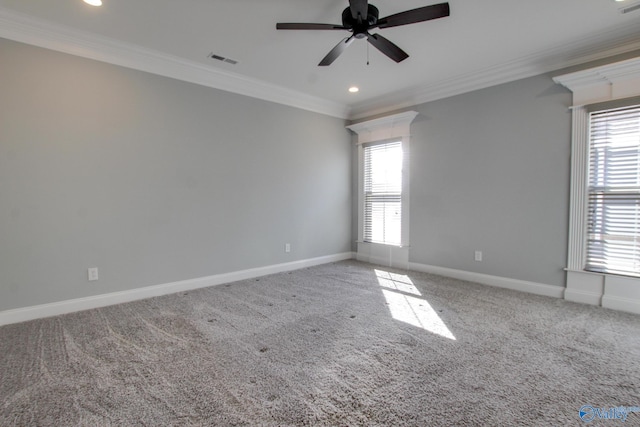 carpeted spare room featuring ornamental molding, a healthy amount of sunlight, visible vents, and baseboards