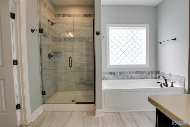 bathroom with a garden tub, vanity, and a shower stall