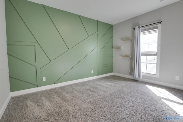 carpeted empty room featuring baseboards