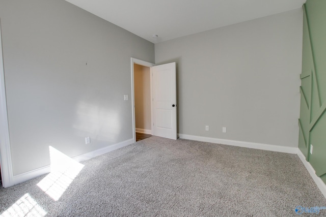 carpeted empty room featuring baseboards