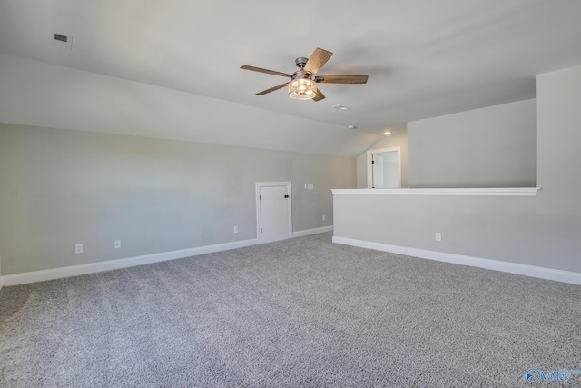 interior space with vaulted ceiling, carpet, a ceiling fan, and baseboards