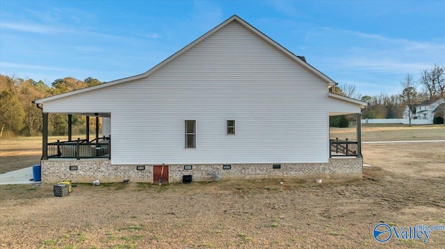 view of side of property featuring a porch and crawl space